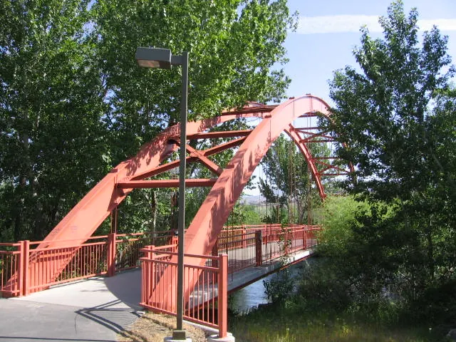 Red pedestrian bridge crossing the Boise River on the Greenbelt