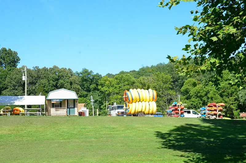 Canoes, kayaks and tubes staged for rent at a riverside livery