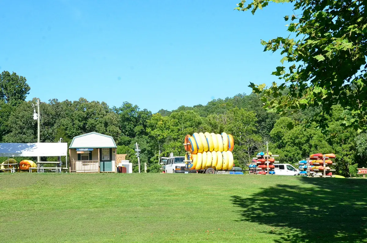 Canoes, kayaks and tubes staged for rent at a riverside livery